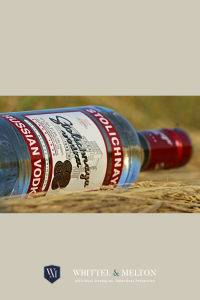 Bottle of vodka laying down on the floor. 
